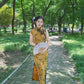 Yellow sleeveless modern qipao with a bamboo print.