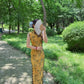 Yellow sleeveless modern qipao with a bamboo print.